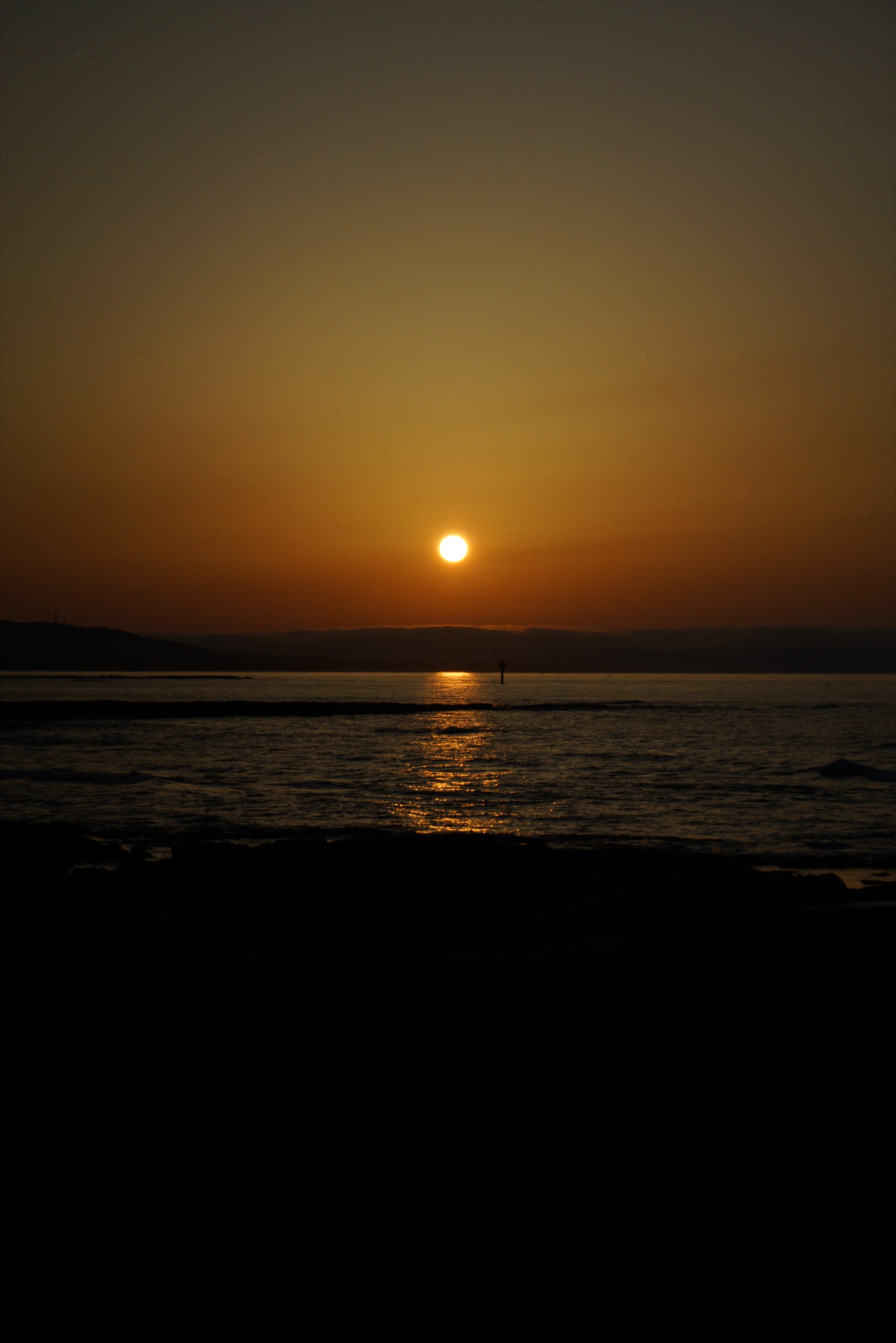 The sun setting over a calm ocean